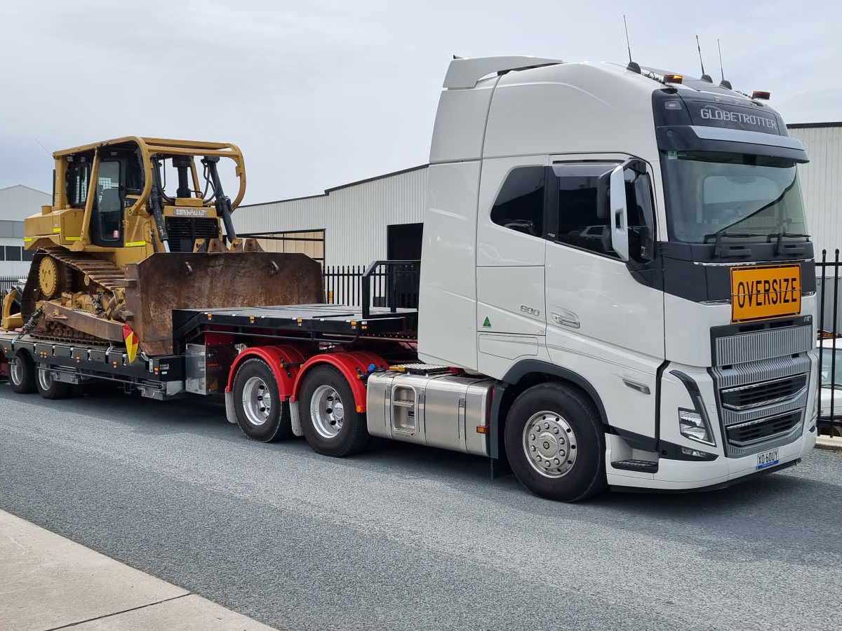 tow truck transporting earth moving machinery